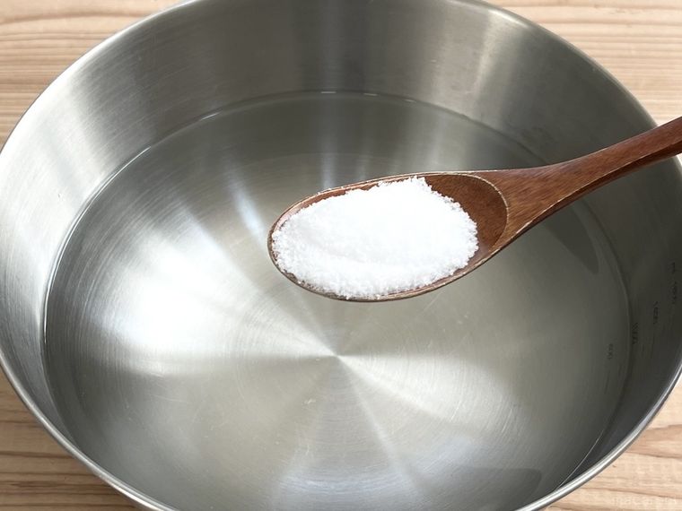 水が入ったボウルに塩を入れようとしている様子