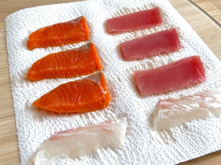 キッチンペーパーで刺身の水気を拭き取っている様子