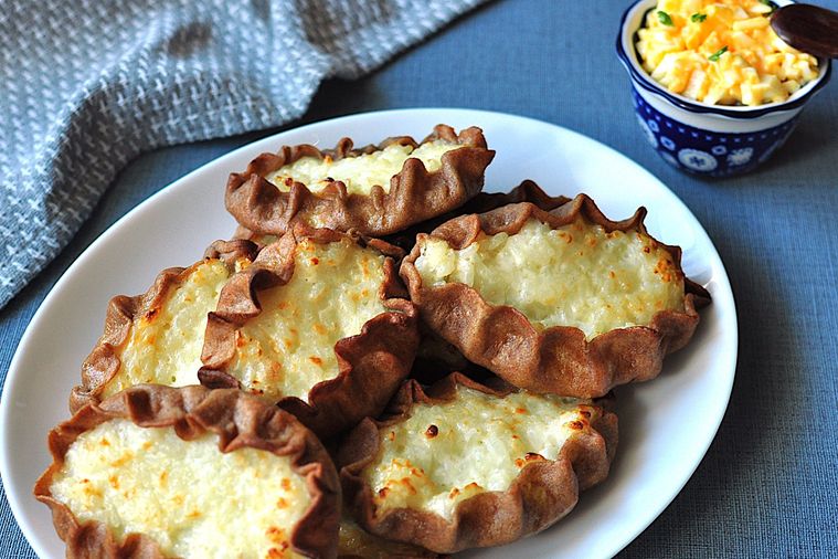 白い楕円形の皿に盛り付けられたカルヤランピーラッカとムナボイ