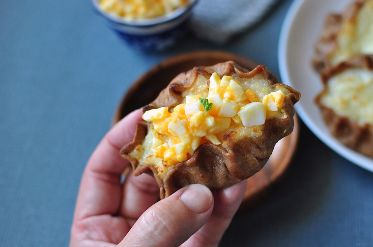 ムナボイをのせたカルヤランピーラッカを手で持つ様子