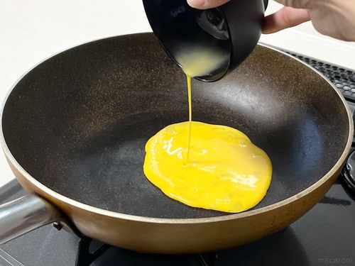 フライパンに卵液を流し込んでいる様子