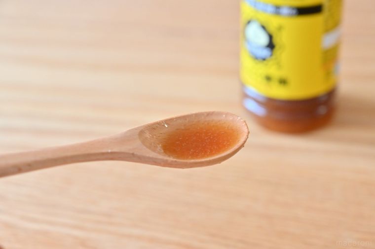 ミツカンLOVERZ たれつゆ にんにく醤油のボトルと木製スプーンにすくった調味料
