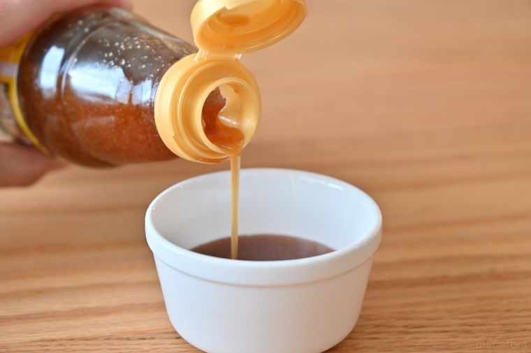 白い容器に液体調味料を注いでいる