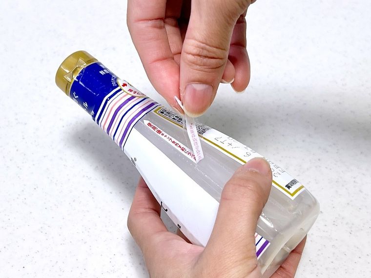 しぼりたて生しょうゆのラベルをはがしている様子