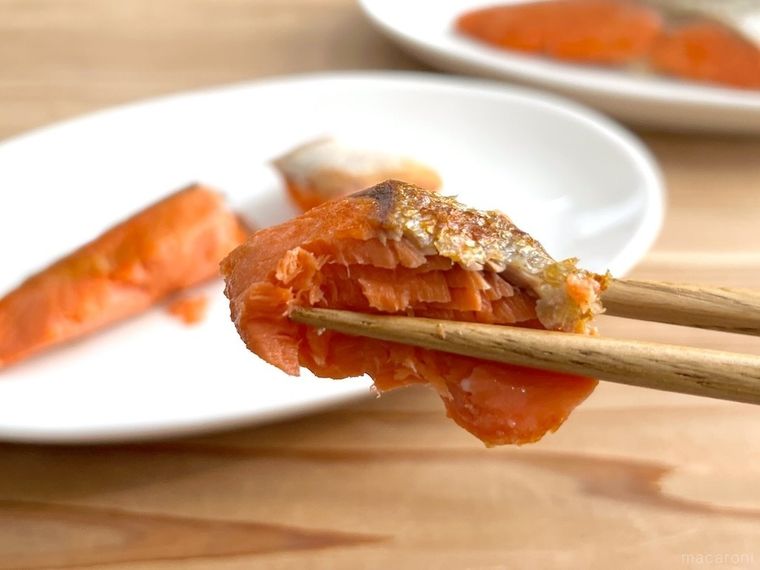 焼き鮭を箸で持ち上げている様子