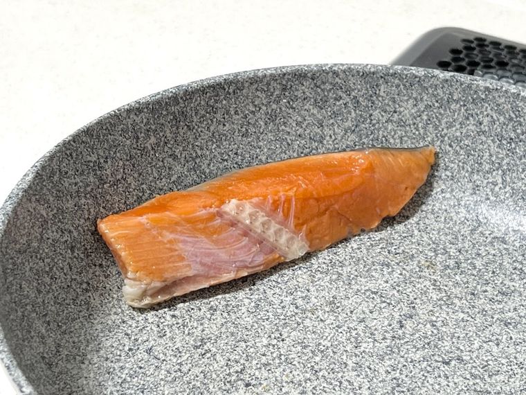 フライパンで鮭を焼いている様子