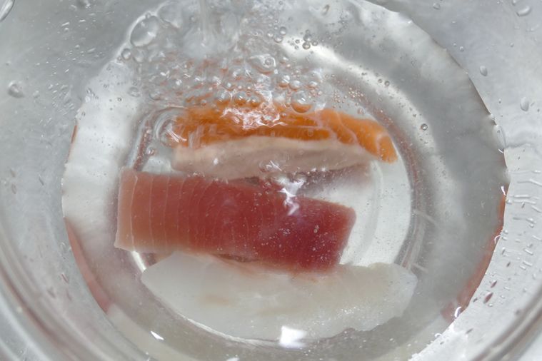 刺身を流水入れたボウルに浸す様子