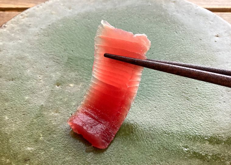 ブライン液で洗ったまぐろを箸で持ち上げる様子