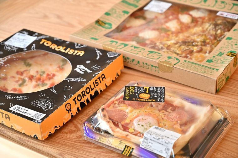 木のテーブルに並んだ3つのピザ