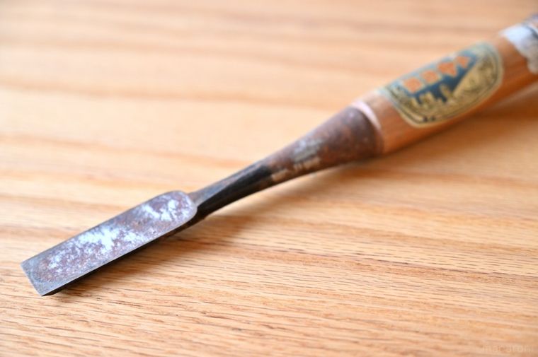 木製テーブルに置かれた1本ののみ