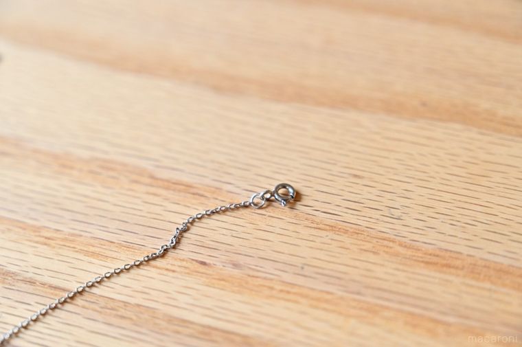 木製テーブルに置かれたネックレスの留め具