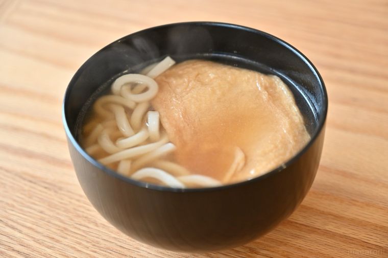 黒い丼に入っているきつねうどん