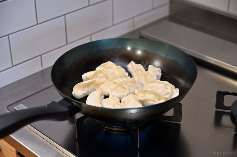 鉄フライパンで冷凍餃子を焼いている
