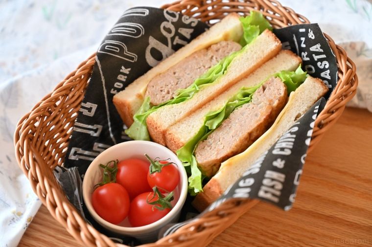 バスケットに入ったハンバーグサンドとプチトマト