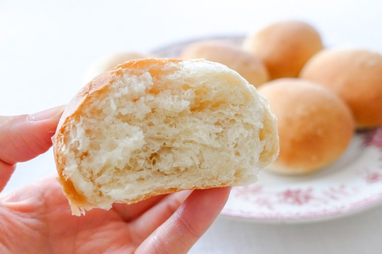 半分に割った丸パンを手で持つ様子