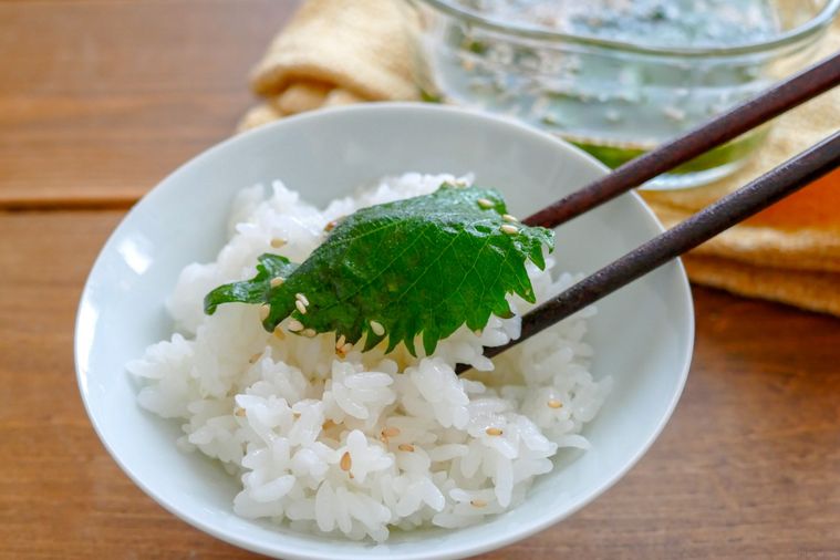 悪魔の大葉漬けをごはんにのせて箸で持ち上げる様子