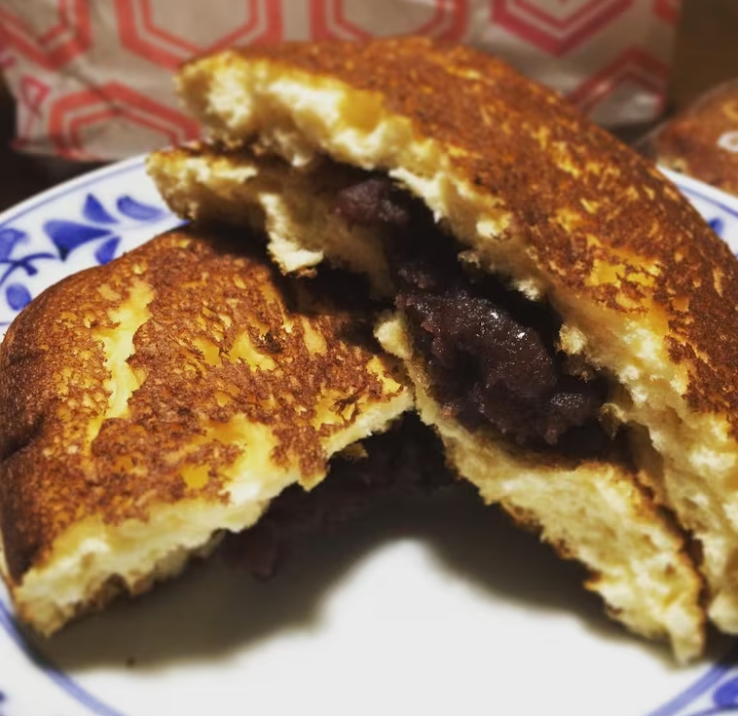 白いお皿に半分に割った亀十のどら焼きがのっている