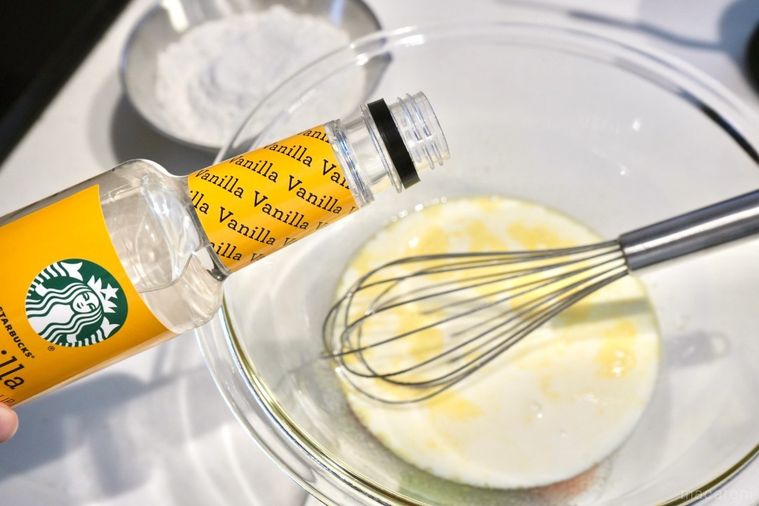 ガラスのボウルで卵と牛乳とバニラシロップを泡立て器で混ぜてパンケーキを作る様子と銀色のステンレスのボウルの薄力粉