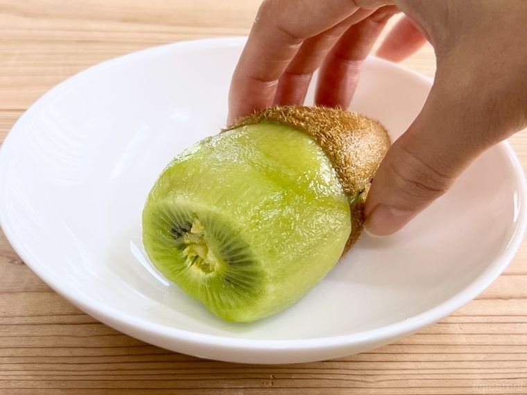 キウイの実を皮から押し出している様子