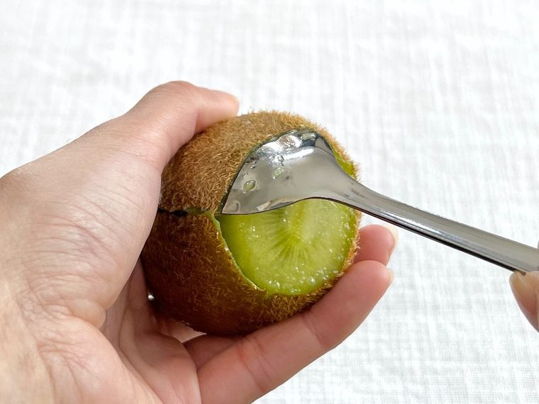 キウイにスプーンを差し込んでいる様子