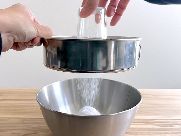 グラスを使って粉をふるっている様子