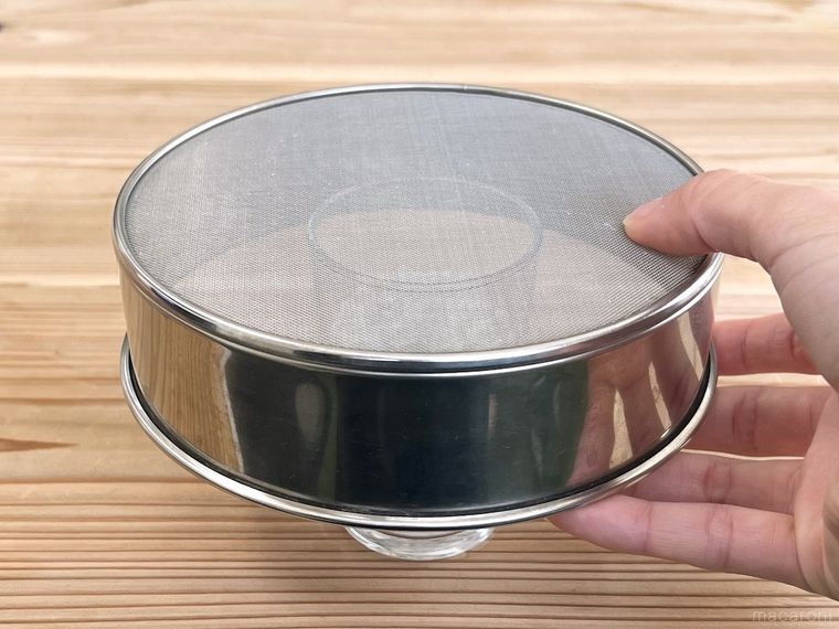 薄力粉が入ったグラスにふるいをかぶせた様子