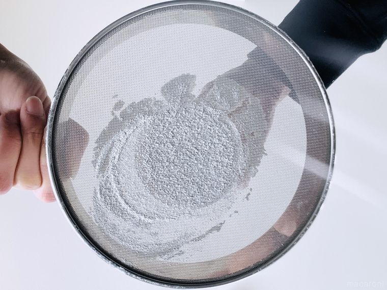 グラスを使って粉をふるっている様子