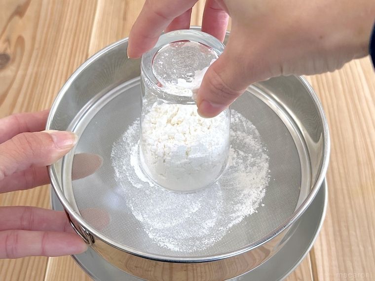 グラスを使って粉をふるっている様子