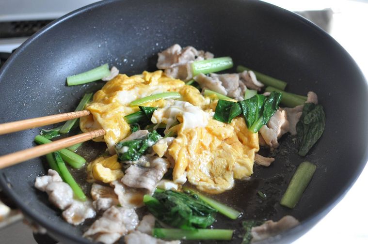 フライパンで小松菜、豚肉、卵を炒めている様子