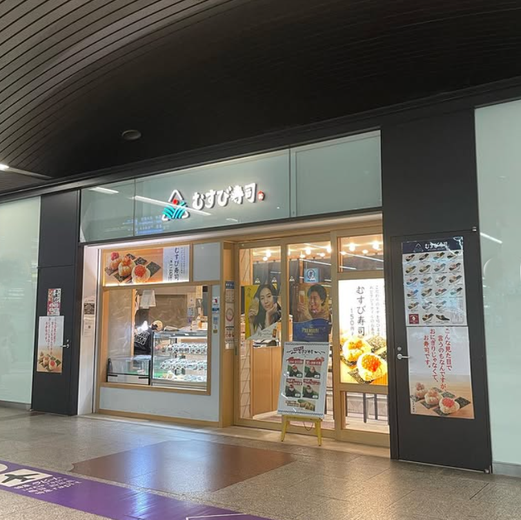 ネオンサインの看板を掲げたむすび寿司 南海なんば駅店外観