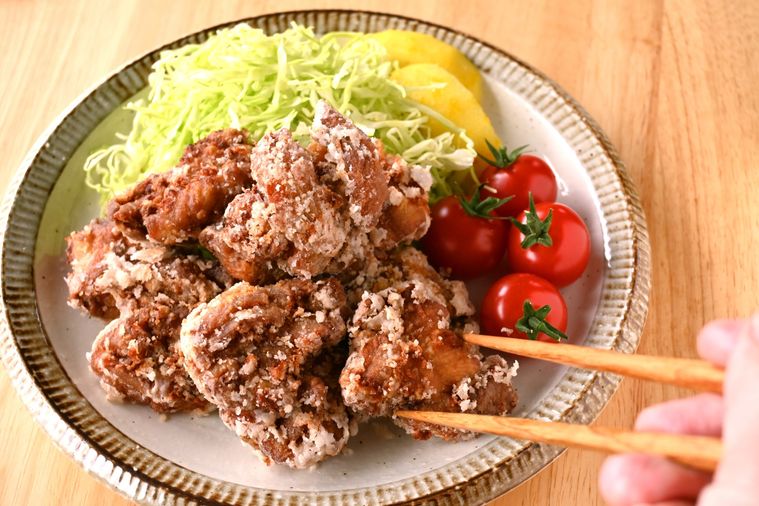 サクサクの鶏唐揚げを箸で摘む様子