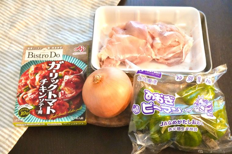 木のカッティングボードにのった料理の材料とストライプの布