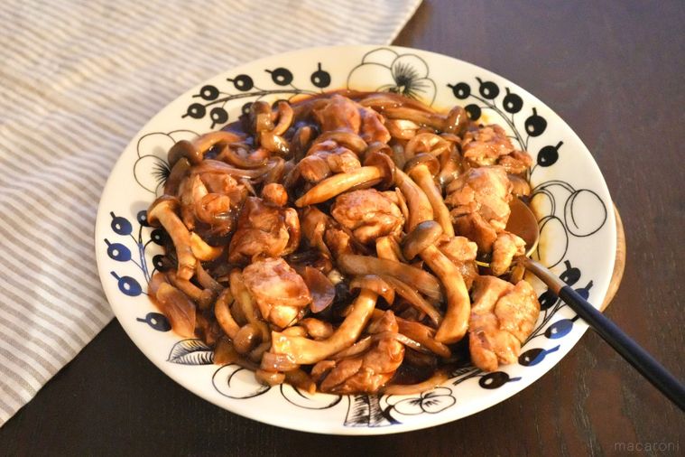 白い大皿に盛られた鶏肉としめじと玉ねぎのデミグラスチキンソテーとストライプの布