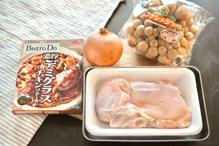 木のカッティングボードにのった料理の材料とストライプの布