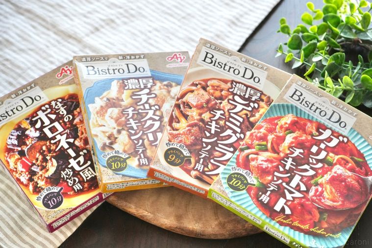 木のカッティングボードにのった料理の素のパッケージとグリーンとストライプの布