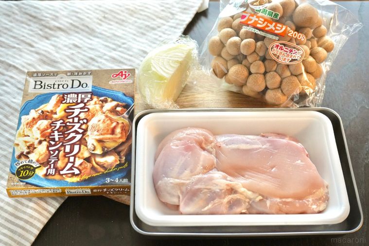 木のカッティングボードにのった料理の材料とストライプの布