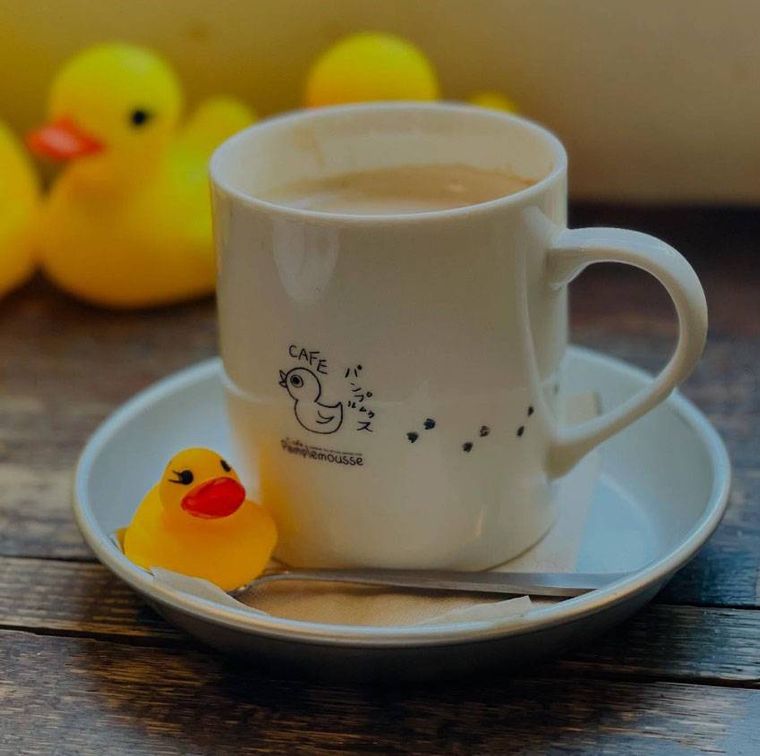 白い店名入りカップに入った「パンプルムゥス 仙台店」のカフェオレ