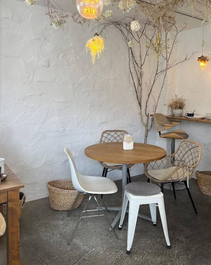 白い壁にテーブルセットのあるイマジネの店内