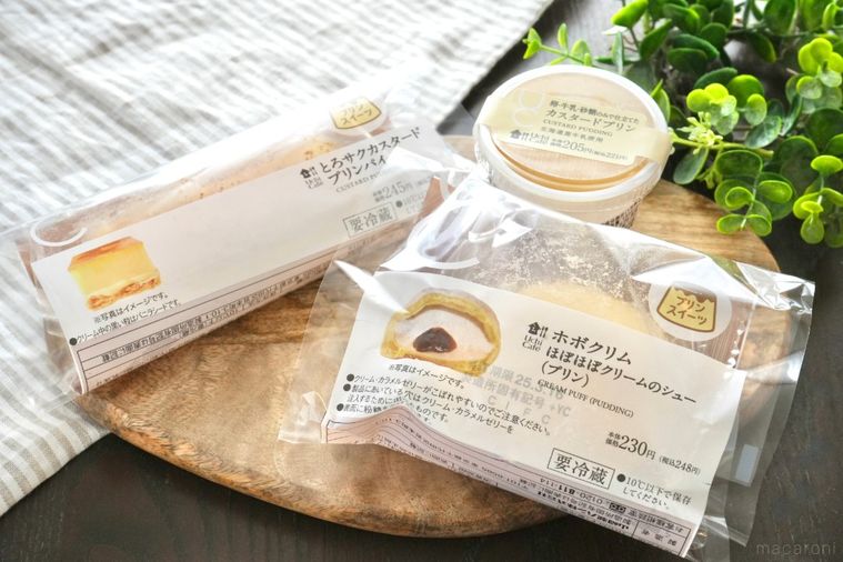 木のカッティングボードにのった3種類のプリン味のスイーツとストライプの布とグリーン