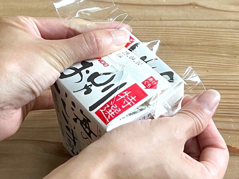 紙パックの口をテープで留めている様子