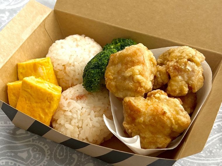唐揚げやおにぎりなどが入ったランチボックス
