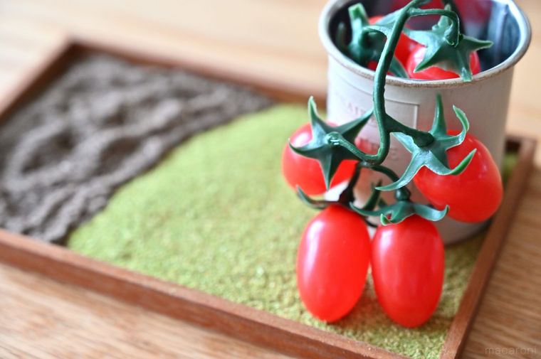 カントリー調の缶にミニトマトのイミテーションを入れている