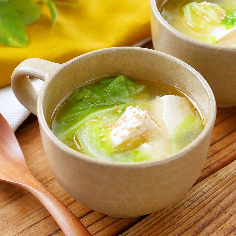 黄土色のカップに注いだキャベツと豆腐の中華スープ