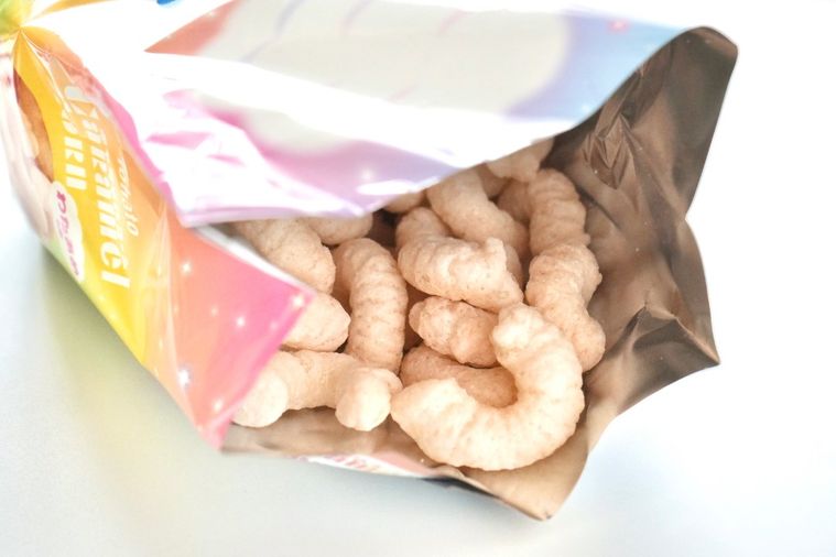 白い背景とパステルカラーのわたあめ味キャラメルコーンの中身を開けた様子