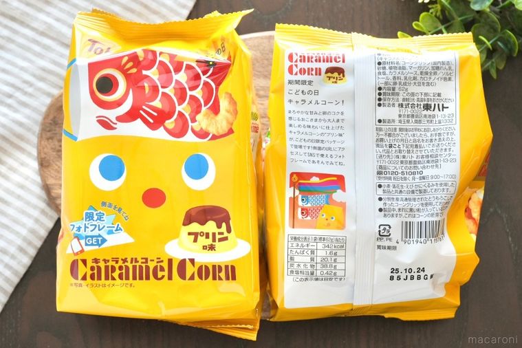 木のカッティングボードにのった黄色い端午の節句バージョンのキャラメルコーンのこいのぼりパッケージとストライプの布