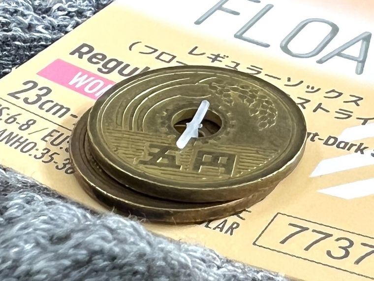 5円玉の穴にタグのピンを通した様子