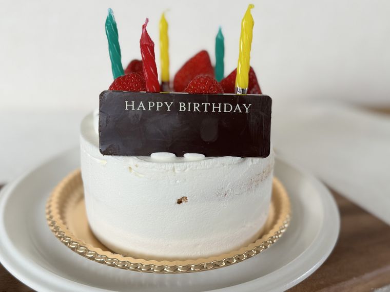 ろうそくとメッセージプレートを飾ったシャトレーゼのいちごの誕生日ケーキ