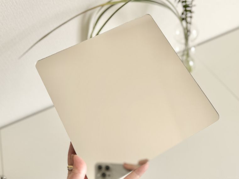 樹脂素材で割れにくいウォールミラーを手で持っている様子