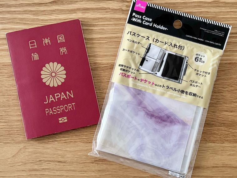 テーブルに並ぶダイソー「パスケースカード入れ付」とパスポート