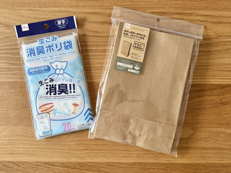 テーブルに並ぶダイソーの紙袋と消臭ポリ袋のパッケージ